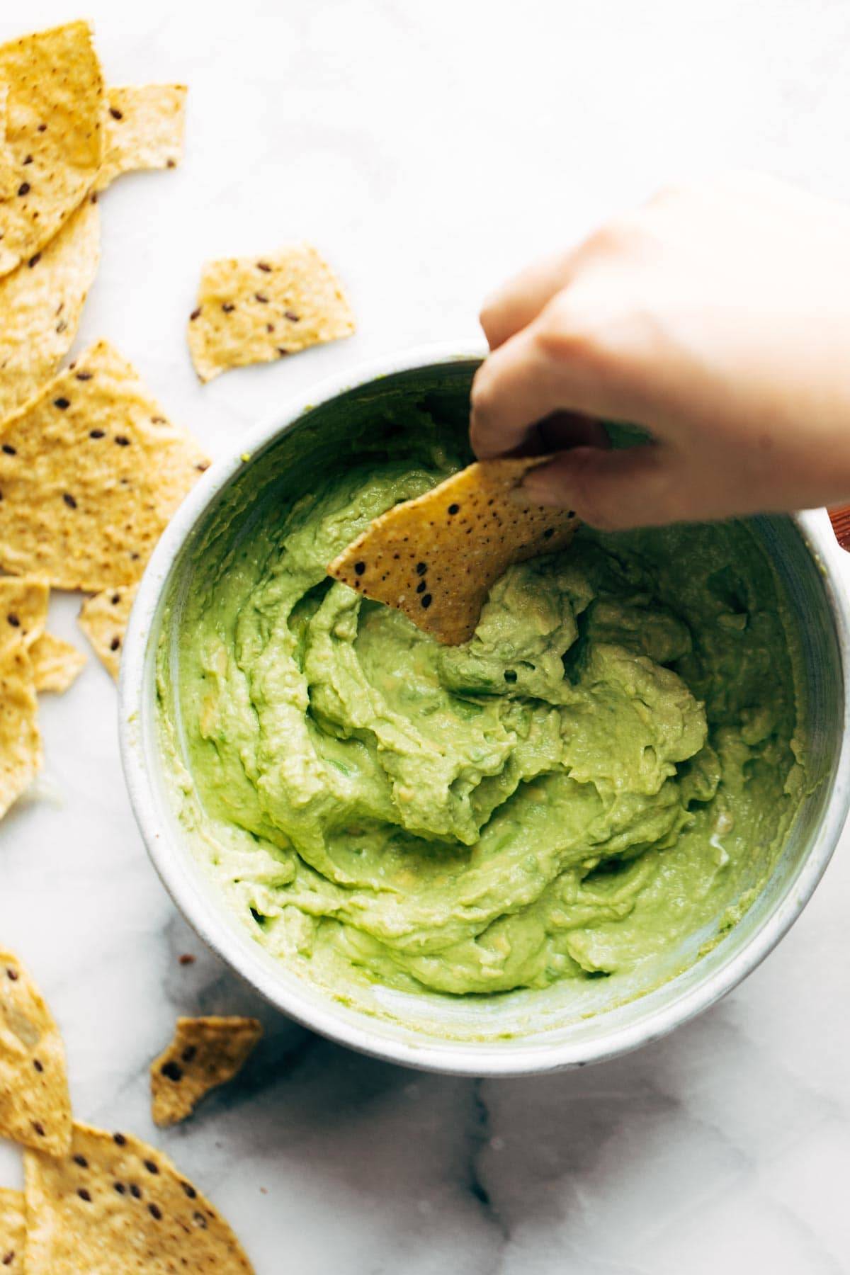 Avocado-Dip-with-Chips A bowl of avocado dip with chips for serving