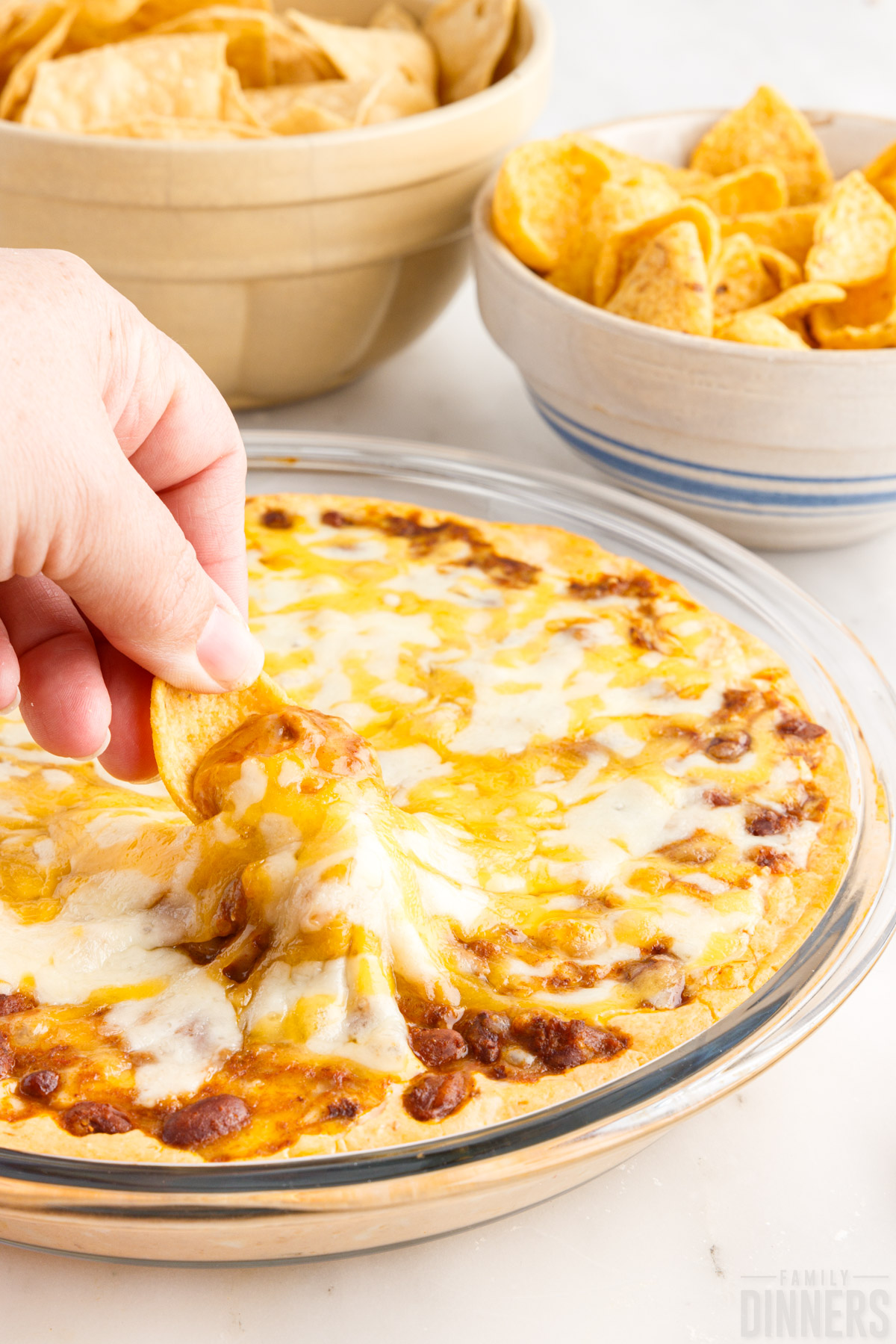 Chili-Cheese-Dip Chili cheese dip on a plate with chips and crackers for dipping