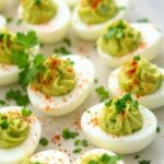 Avocado deviled eggs on a white ceramic plate