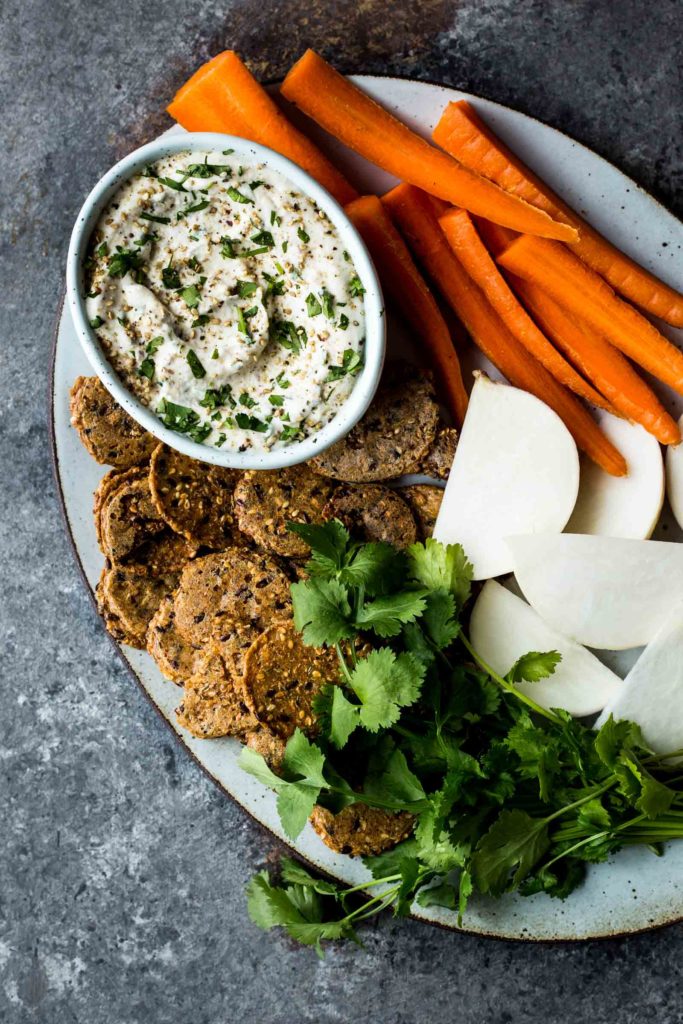 Miso-Tahini-Cauliflower-Dip Bowl of miso cauliflower dip on a platter with carrots and vegies for dipping
