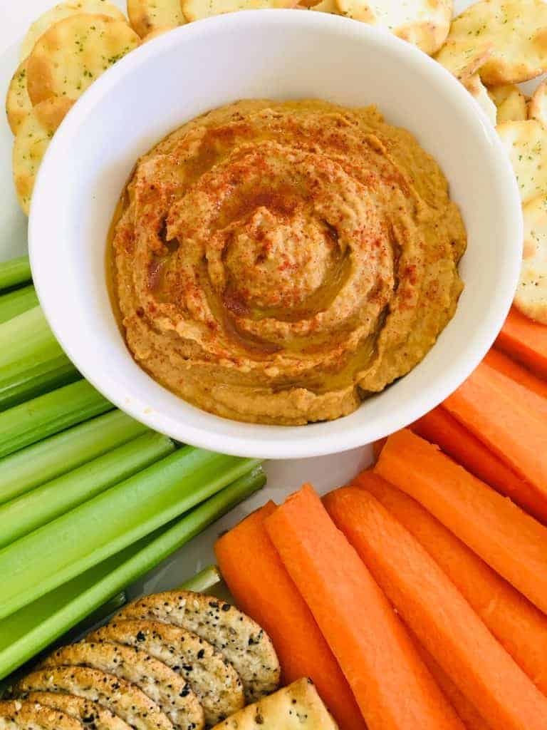 Peanut-Butter-Hummus Bowl of peanut butter dip and vegetable sticks - carrots and celery- and chips